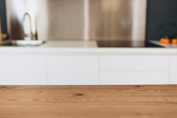 Empty wooden table with the bright white interior of the kitchen as a blurred background. For mock up