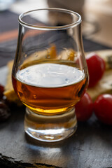 Whiskey and cheese pairing, tasting whisky glass and plate with sliced blue stilton and blue shropshire cheeses, Great Britain food and drink