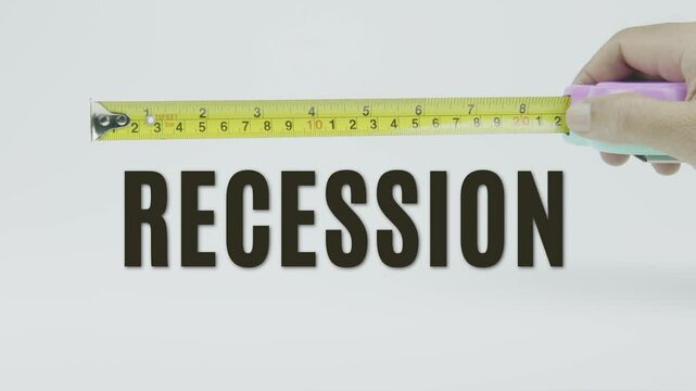 "Recession" text with a yellow tape measure on a white background, symbolizing precision, accuracy, and the measurement of economic decline and financial trends in a clean, minimal video