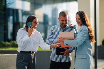 Business people having conversation while holding documents and talking on phone
