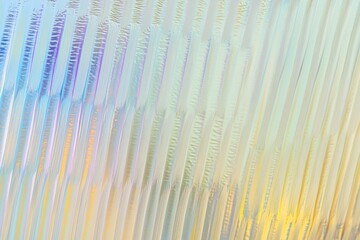Close-up texture of rippled glass background. Abstract wallpaper featuring bright iridescent hues.