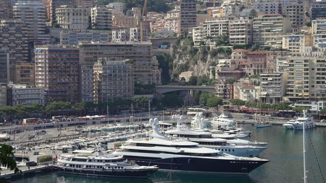 Harbor of Monaco with luxury yachts and the city in the background.