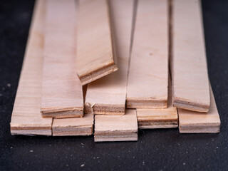 Oblong pieces of plywood on a black background.