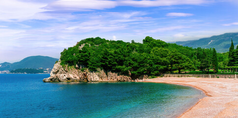 amazing summer season sea beach with golden sand , rochy coast with green forest , beautiful blue sea bay water and cloudy sky on background