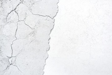 Obraz premium A close-up of a textured white wall featuring visible cracks and a smooth surface.