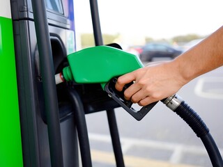 Person Refueling a Hybrid Vehicle with HVO Fuel at an Alternative Energy Station, Sustainable Mobility