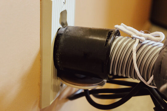 close-up of a residential central vacuum hose wall hook up to the wall plate for cleaning. macro photography graphic element.