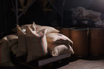 Large burlap sacks filled with raw green coffee beans, prepared for processing and roasting