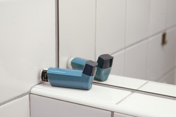 Asthma inhaler reflected in bathroom mirror