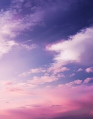 Obraz premium A gentle, dreamy sky with a gradient of pink and purple shades, adorned with wispy white clouds.