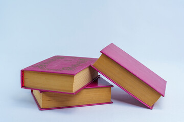 Stack of three vintage hardcover books on neutral background