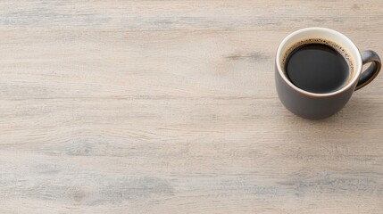 Dark coffee in grey mug on light wooden table