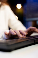 Freelancing computer scientist typing on keyboard, implementing security measures to protect...