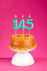Birthday cake with number 145 candle - Anniversary card on a pink background.