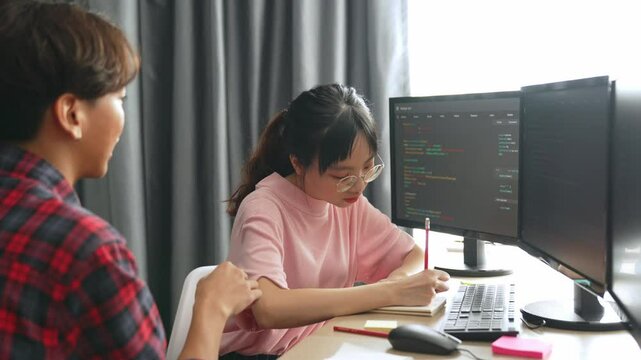 Slow motion back end software developer engineer for computer programming working together on debugging writing computing code, solving complex algorithms display on monitor in office. Burgeoning