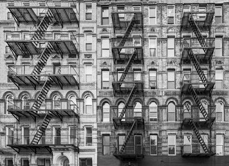Old apartment buildings with fire escapes in the East Village of New York City in black and white