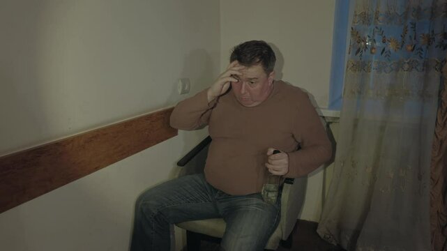 An old drunk alcoholic in a dark room. Alcoholic problems. Depression, delirium tremens.An old drunk alcoholic in a dark room. Alcoholic problems. Depression, delirium tremens.