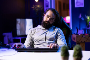 Man obsessed with playing videogames all day falling asleep at computer desk, feeling tiredness. Gamer suffering from gaming addiction feeling extremely sleepy, dropping from chair