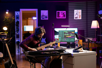 Sound engineer recording his acoustic guitar accords in home studio, working on mixing and...