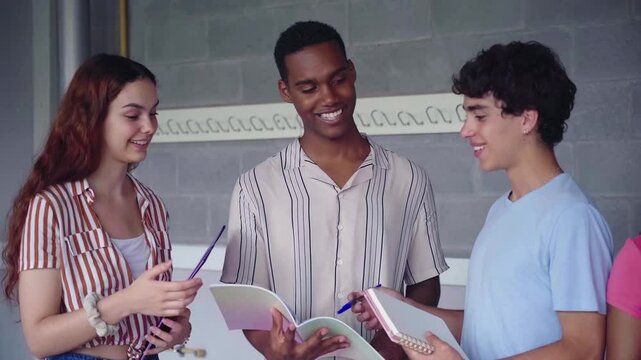 Cheerful multiracial teamwork of university students gathered in classroom talking about a school project.