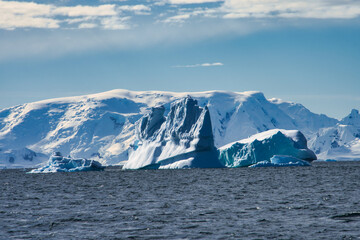 Antarctic Peninsula iceberg, snow-capped mountains.