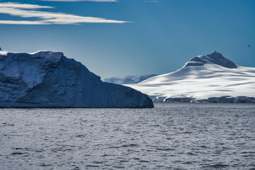 Antarctic Peninsula iceberg, snow-capped mountains.