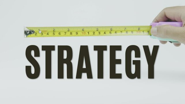 "Strategy" text with a yellow tape measure on a white background, symbolizing precision, accuracy, and planning in a clean, minimal video