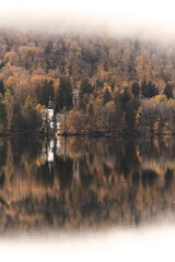 House on the lake in Slovenia. Reflection of the house in the lake with mist.