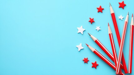 Obraz premium Colorful Red Pens and White Stars Arranged on Bright Blue Background for Creative Atmosphere