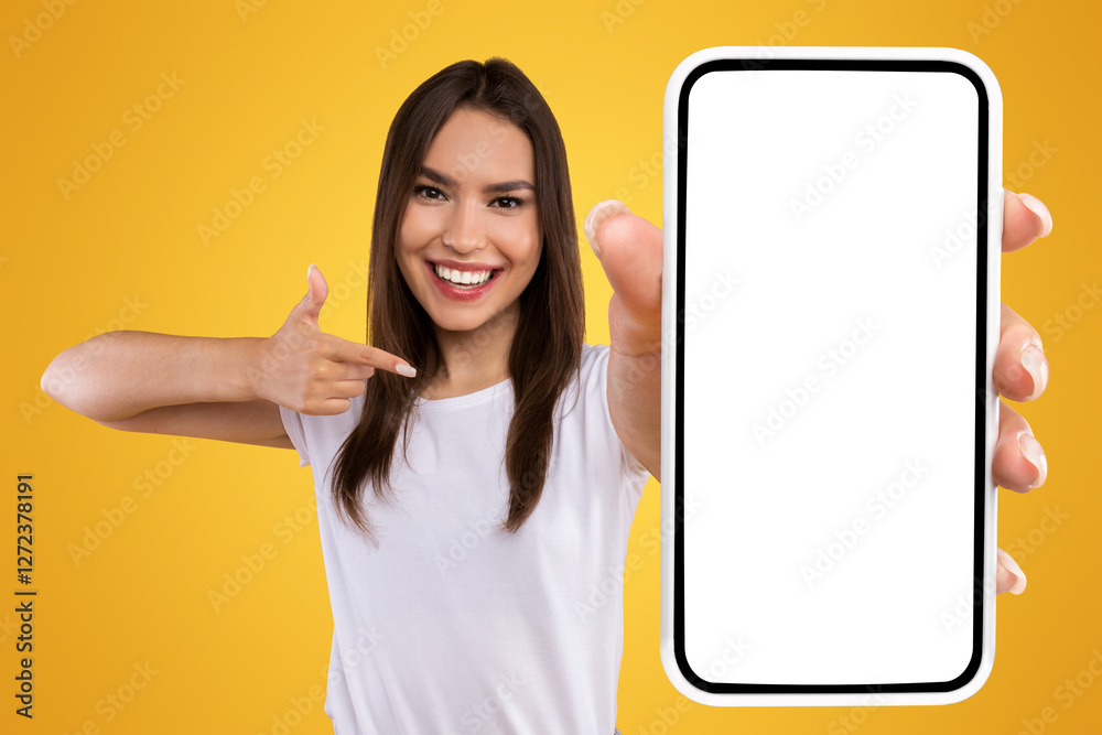 Aufkleber Check This Website. Portrait of smiling female holding smartphone with white blank screen in hand, showing device close up to camera and pointing finger at gadget with empty free space for mock up