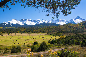 Hay bales in front of snow capped mountains near Ridgway, Colorado, USA