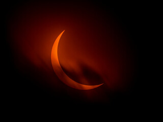 Dark clouds roll by partial solar eclipse