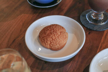 Craquelin Choux biscuits filled vanilla and milk custard on wooden table. Fresh Baked Bakery for coffee break or party