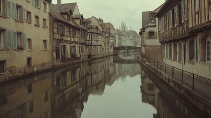 Calm canal reflecting historic half-timbered buildings.
