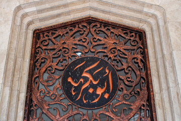 Ornate Metal Door with Intricate Arabic Calligraphy, Architectural Detail, Cultural Heritage