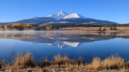 Snow capped mountain reflected in calm lake water