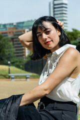 Elegant latin businesswoman fixing her hair in urban park