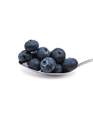 Close up of fresh and ripe organic blueberries on a metal spoon. Healthy berry fruits isolated on white background