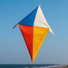 Colorful kite soaring against a clear blue sky over a sandy beach
