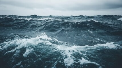 Rough sea with powerful waves crashing. Dramatic ocean scene under a cloudy sky.