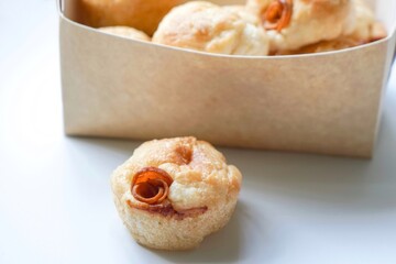Close up view of Sourdough Focaccia Bread Muffins with pepperoni on white background in selective focus.