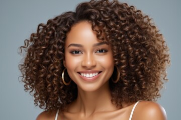 smiling woman with curly hair and hoop earrings posing for a picture