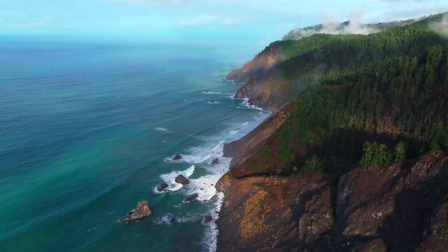 PNW Lost Coast Trail rugged dramatic untouched coastline aerial drone California surf waves boulder rocks USAL Beach campground cloudy shaded mist fog sun rays morning nature landscape forward pan up