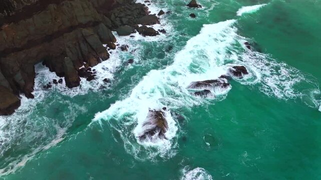 Waves crashing black sand boulder rocks rugged coastline USAL Beach Campground Lost Coast Trail California Birdseye aerial drone fog mist rain cloudy layers morning Pacific Ocean static shot