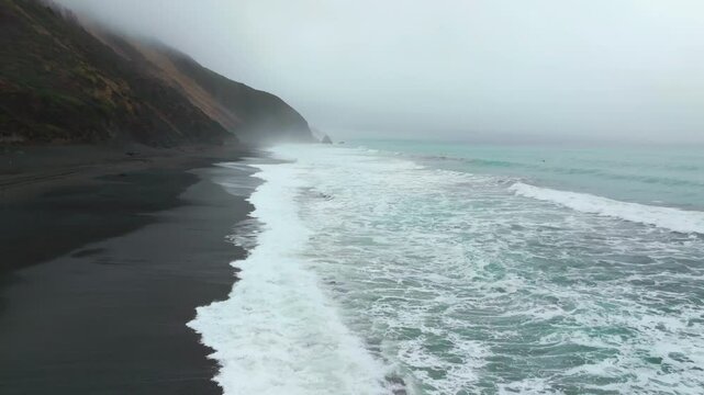 Waves Crashing on black sand rugged coastline USAL Beach Campground Lost Coast Trail California fog mist rain cloudy morning Pacific Ocean PNW Nor Cali boulders cliff mountainside static shot