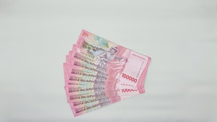 Collection of 100,000 rupiah banknotes on white background