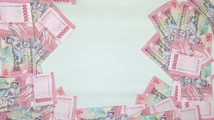 Collection of 100,000 rupiah banknotes are arranged like frame for copy scape. 