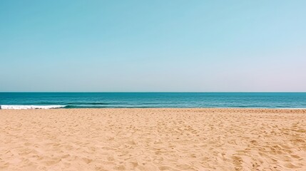 Obraz premium Empty sandy beach meets calm ocean blue sky