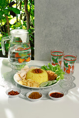 a complete plate of yellow rice which is Indonesian food