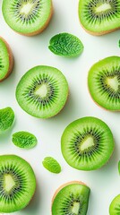 Fototapeta premium Bright and refreshing kiwi fruit slices are artfully displayed alongside mint leaves, showcasing their unique texture and color against a clean, white background
